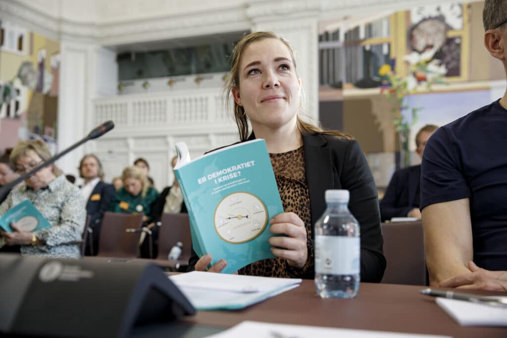 Kvinde læser i Demokratikommsionens betænkning