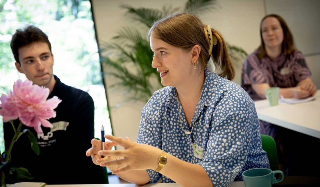 Ung kvinde forklarer noget til seminar