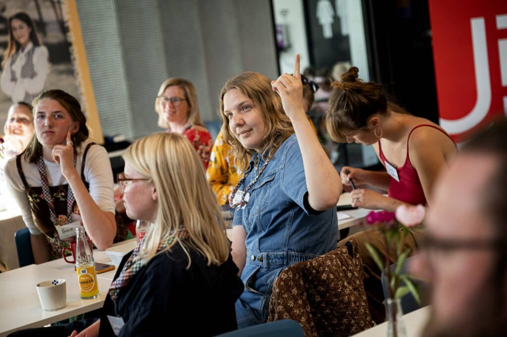 Ung kvinder rækker hånden i vejret