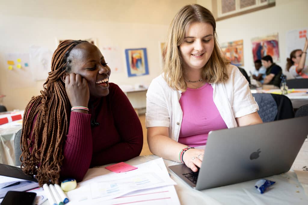 To unge kvinder skriver på computer