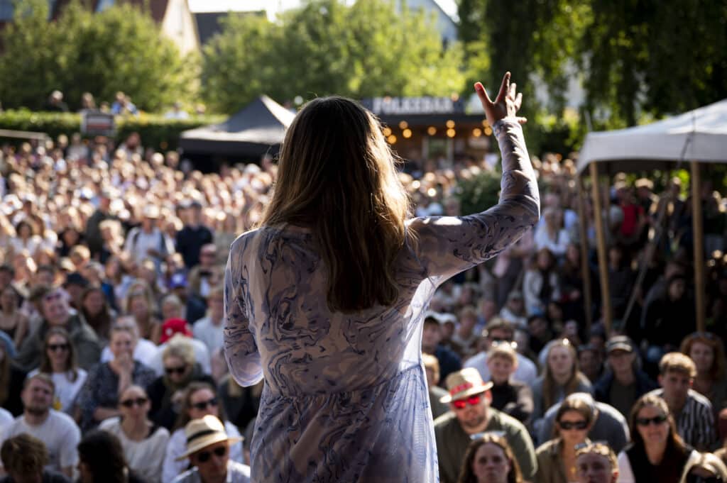 Ung kvinder står på scenen til DM i Debat.