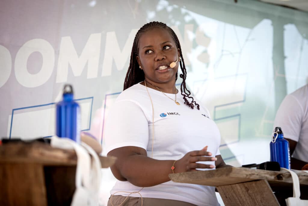 Ung kvinder taler i mikrofon på scenen.