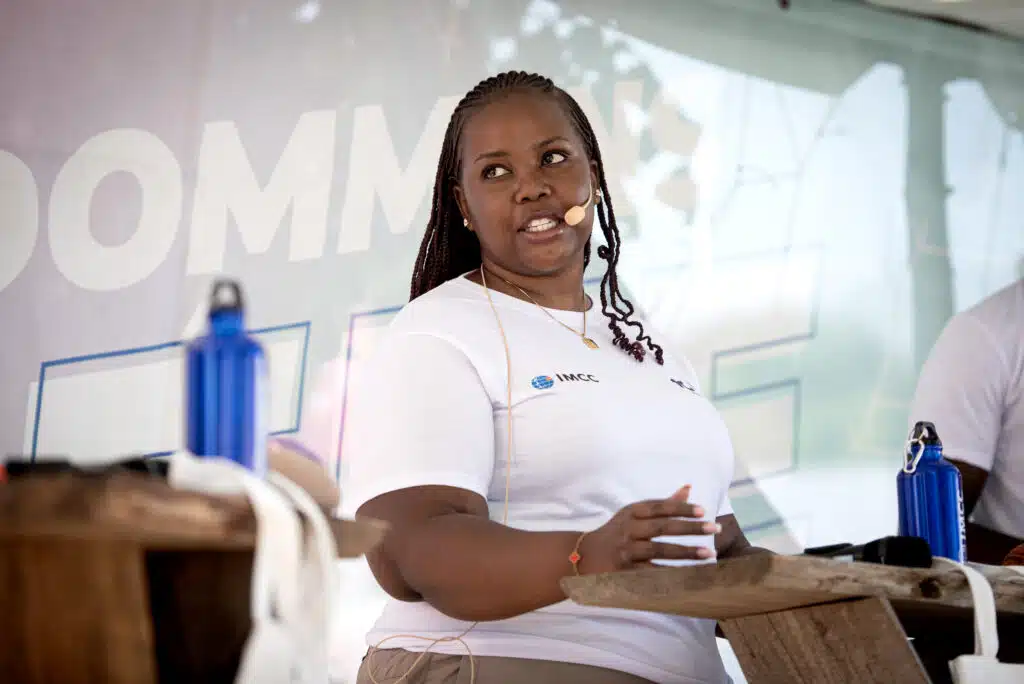 Ung kvinder taler i mikrofon på scenen.