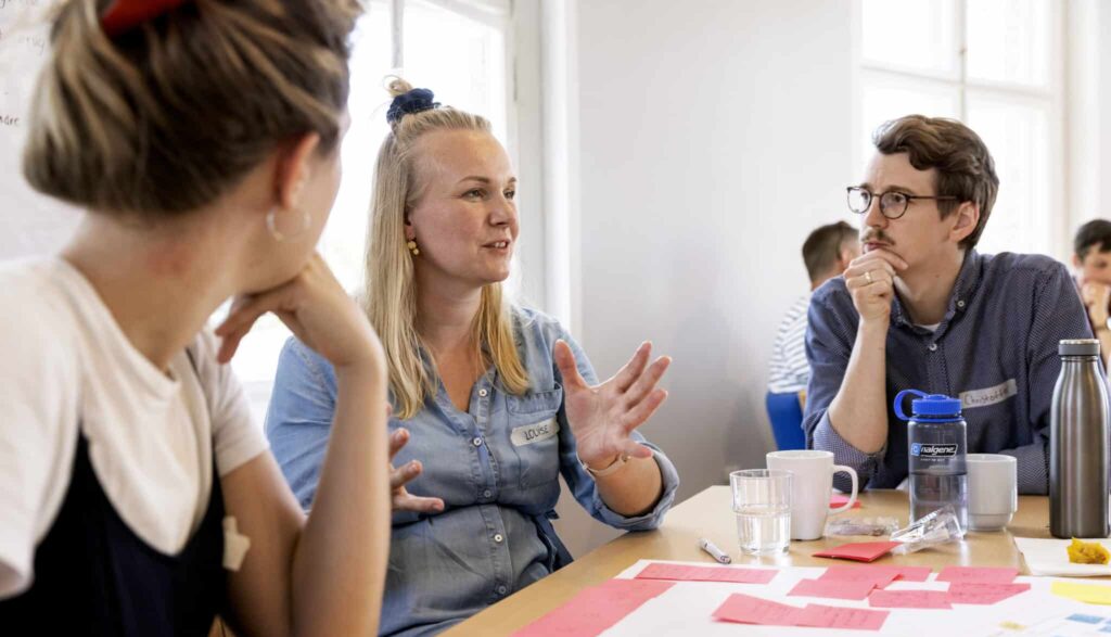 Ung kvinder forklarer noget til en workshop