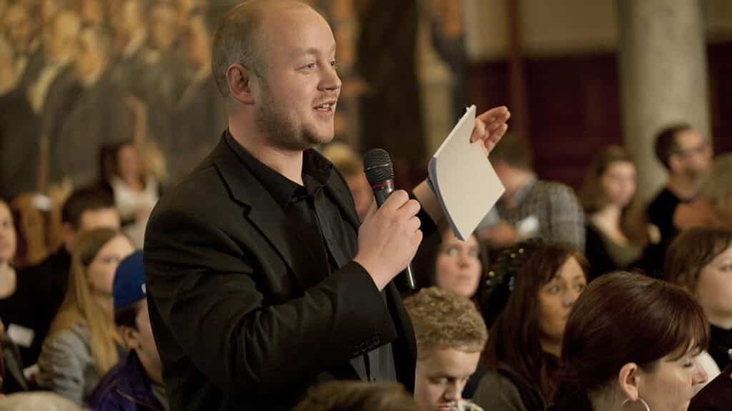 Mand snakker i mikrofon