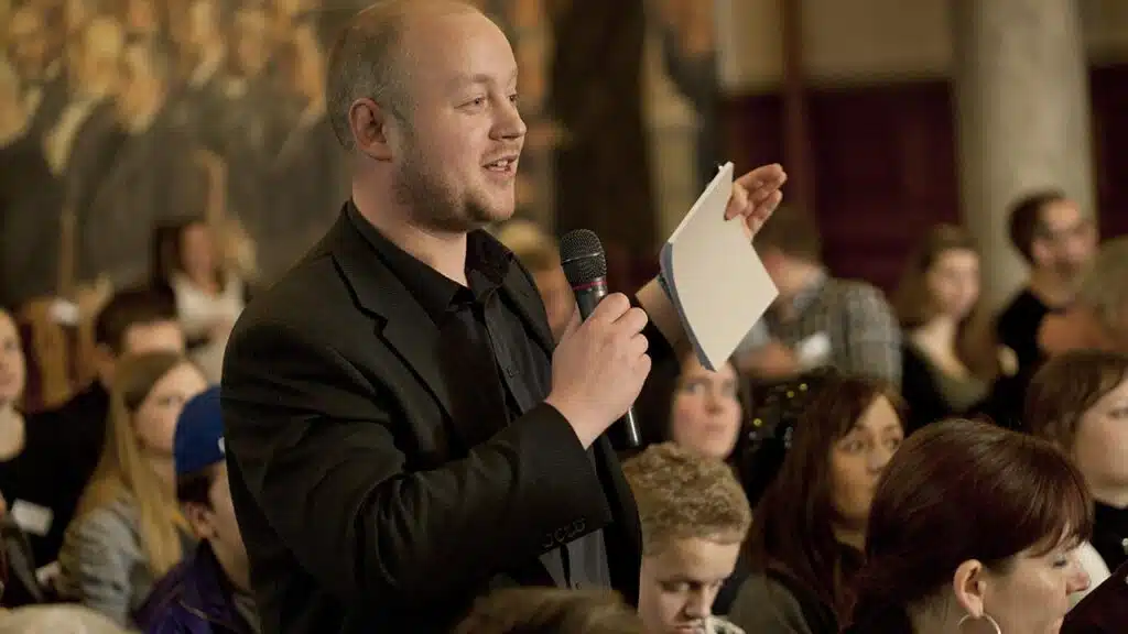 Mand snakker i mikrofon