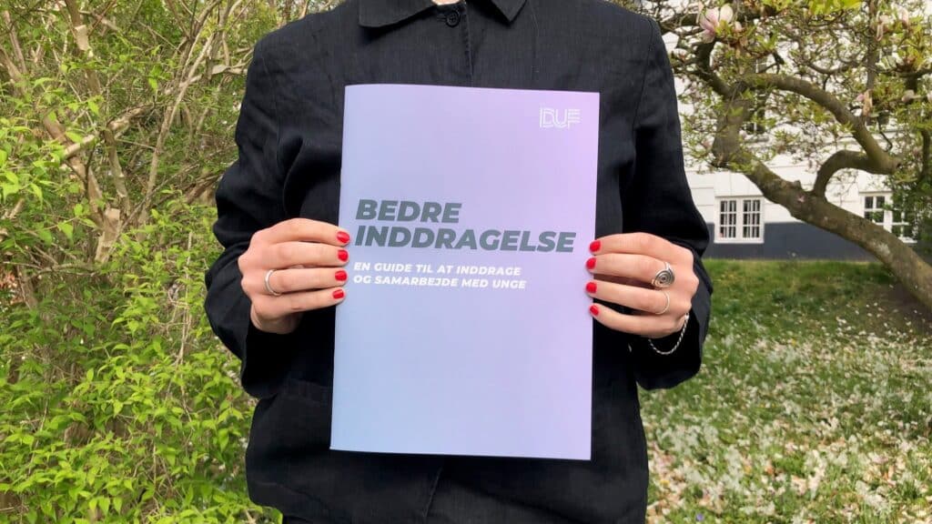 Hænder der holder DUFs publikation "Bedre Inddragelse"